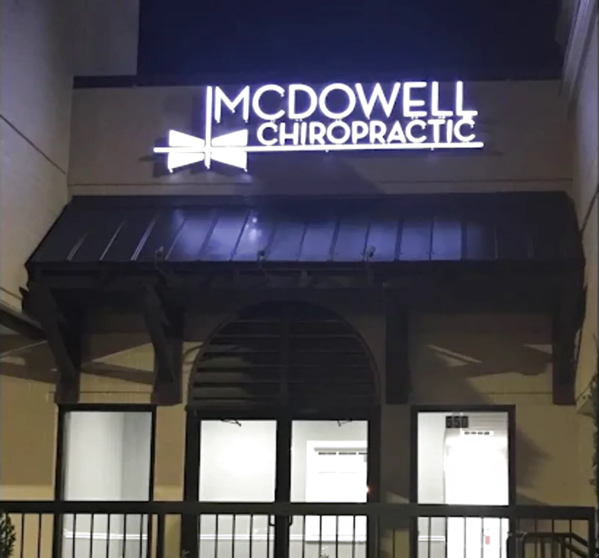 Illuminated McDowell Chiropractic sign above the entrance of the Roswell, Georgia office on Holcomb Bridge Road