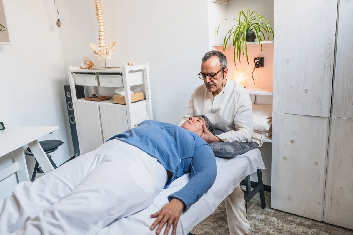 Chiropractor supporting a patient's head and upper neck during a gentle upper-cervical adjustment